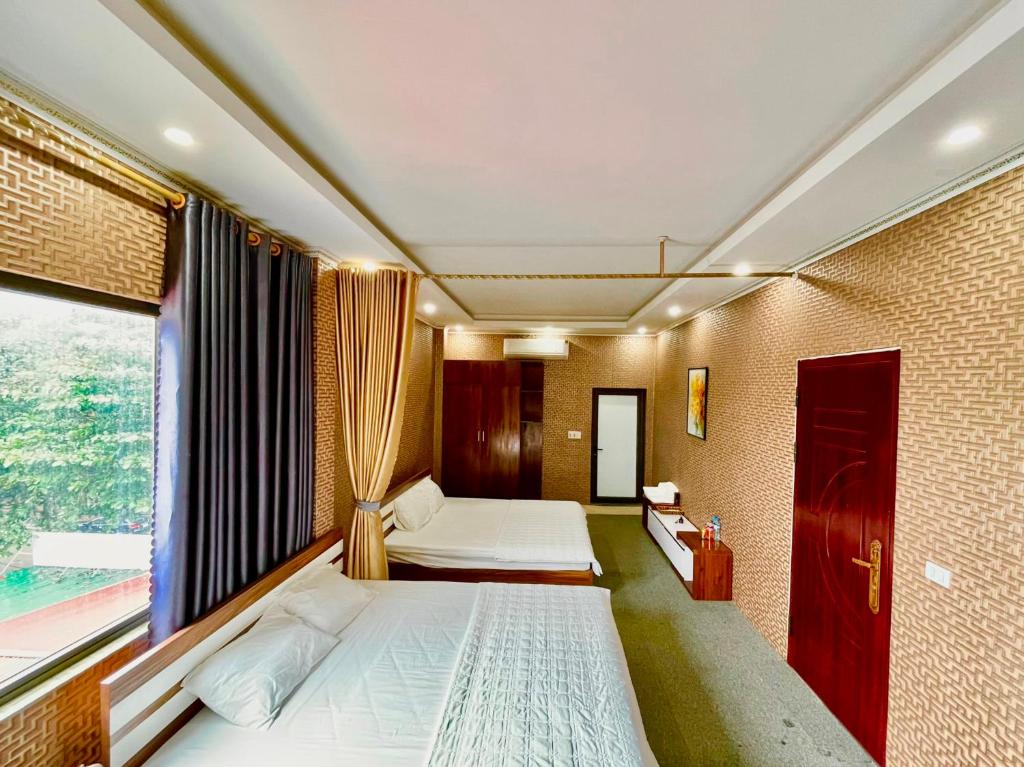 een slaapkamer met 2 bedden en een raam bij Cô Chung Hotel in Lao Cai