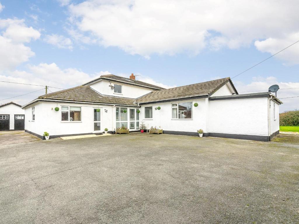 a large white house with a large driveway at 5 Bed in Mold 79345 in Llanferres