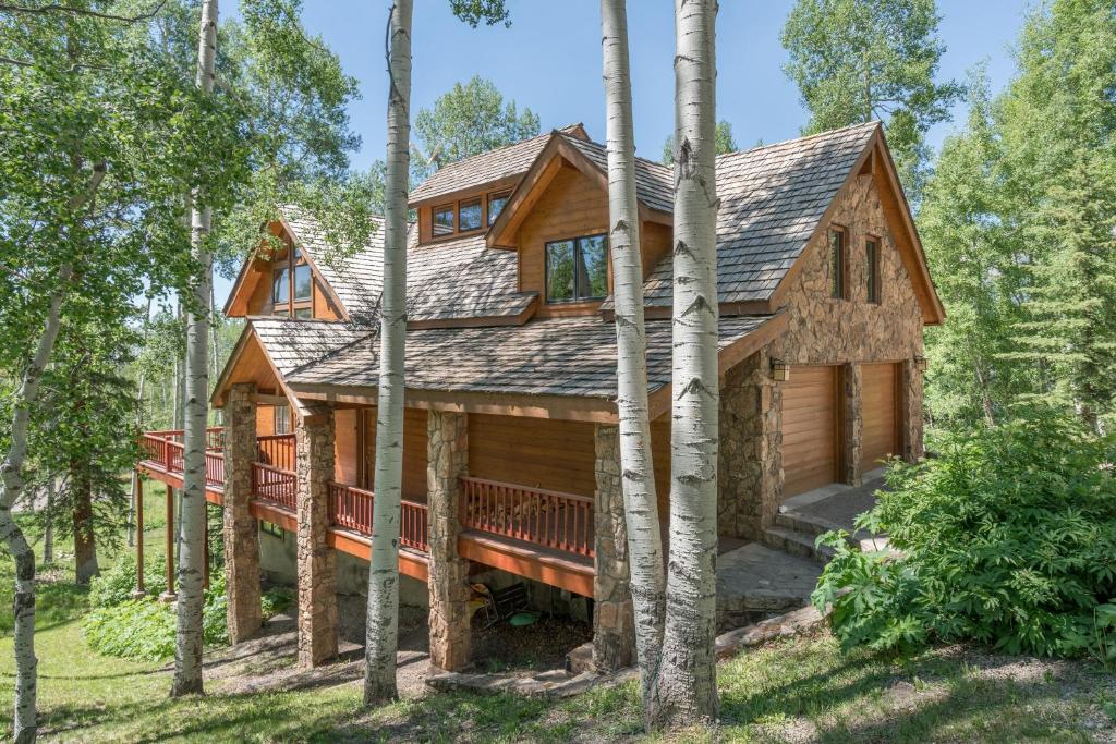 domek wiejski z werandą w lesie w obiekcie Wapiti Mountain Escape by AvantStay Commanding Views Incredible Home w Hot Tub w mieście Telluride