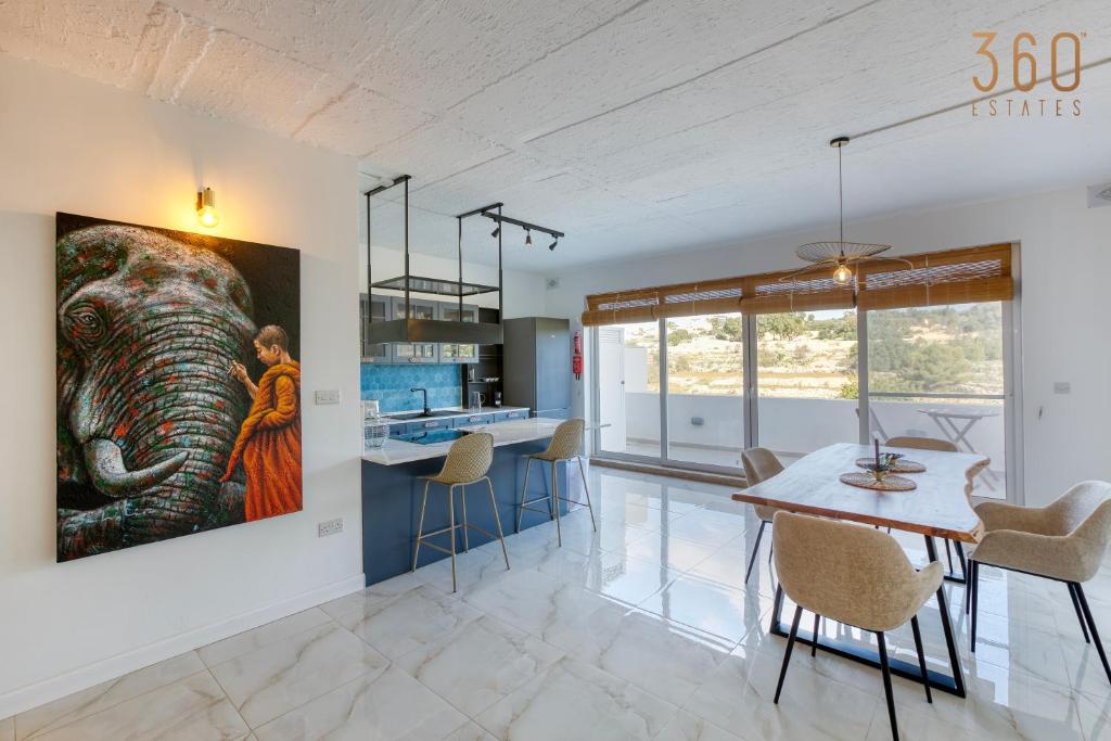 a kitchen and dining room with a painting of an elephant at A lovely, central 2BR penthouse with large outdoor by 360 Estates in LʼInglin