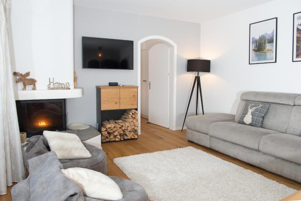 uma sala de estar com um sofá e uma lareira em Sundroina holiday flat for two people Lenzerheide centre em Lenzerheide