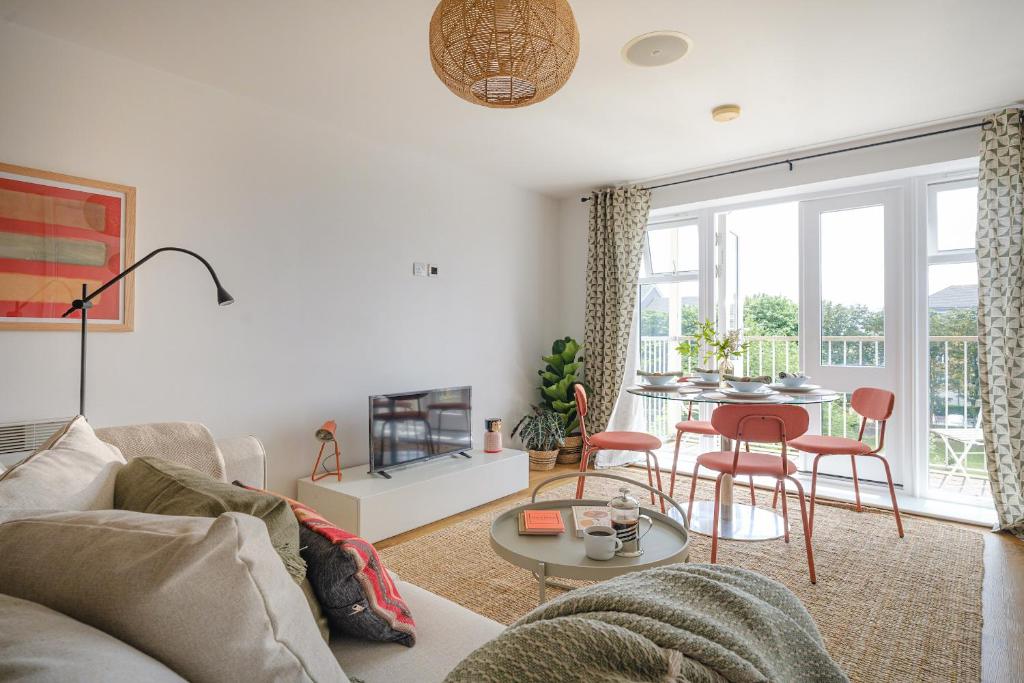 ein Wohnzimmer mit einem Sofa und einem Tisch in der Unterkunft Hauzify I Cavendish flats in West Drayton