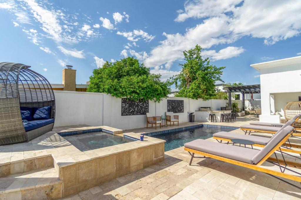 a patio with a swimming pool and lounge chairs at Opal by AvantStay Central Scottsdale Luxe Home in Scottsdale