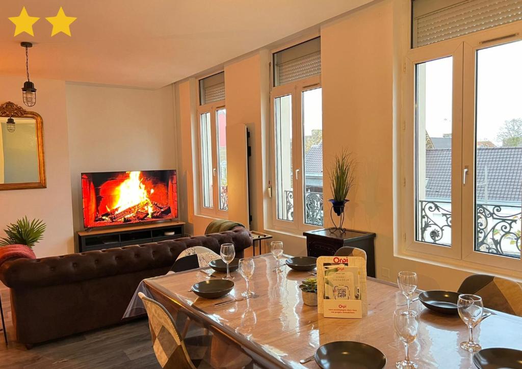 un salon avec une table et une cheminée dans l'établissement Le Roof Top Jacquard, à Calais