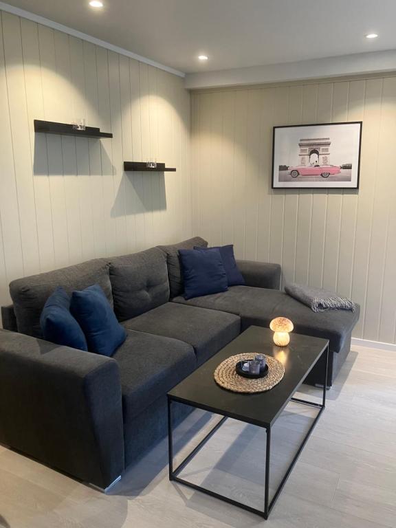 ein Wohnzimmer mit einem Sofa und einem Tisch in der Unterkunft Koselig, nyoppusset leilighet in Gjøvik
