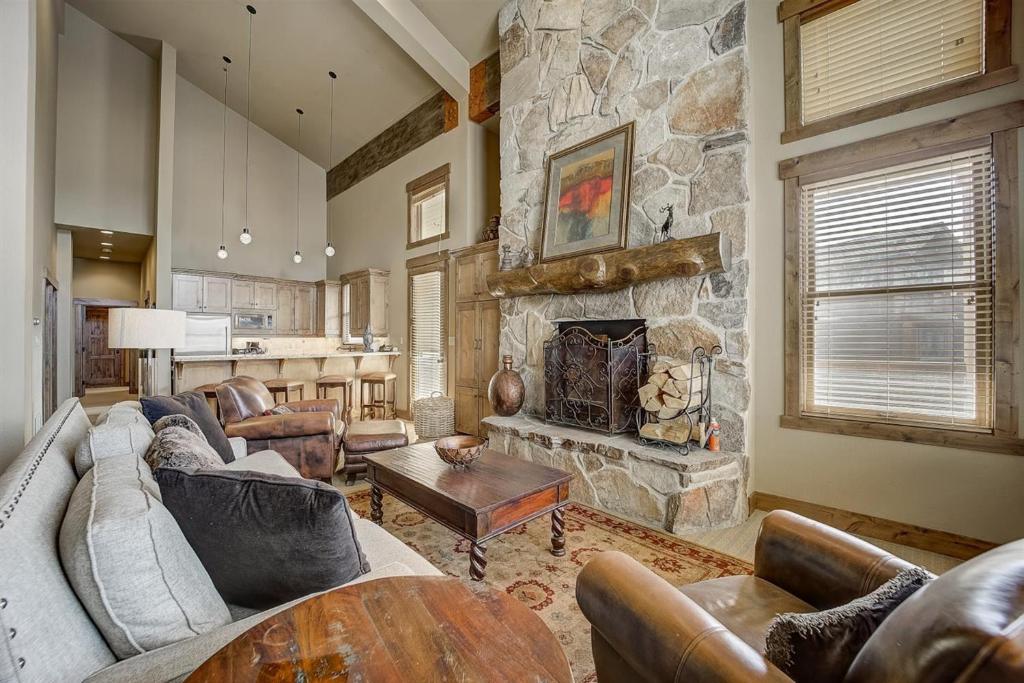 a living room with a stone fireplace and couches at Mont Cervin 32 by AvantStay Ski In Ski Out Home in Silver Lake Village w Hot Tub in Park City