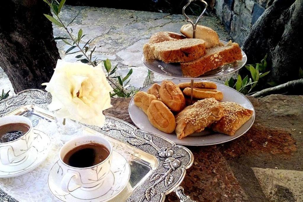 two plates of pastries and cups of coffee on a table at Elia - seaside place in Agios Nikolaos