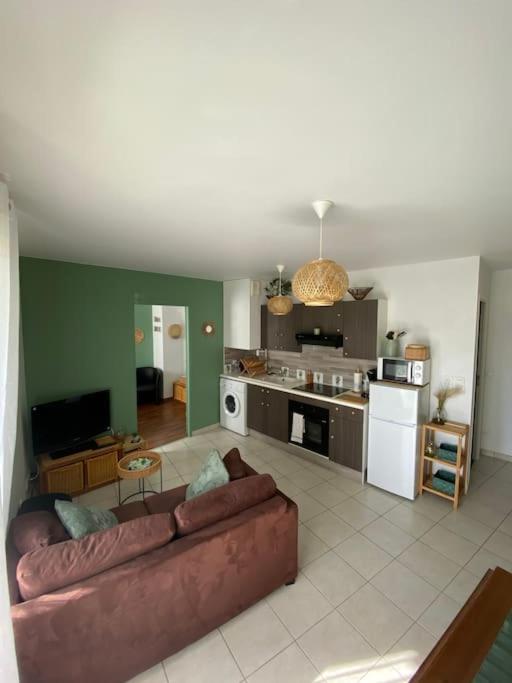 uma sala de estar com um sofá e uma cozinha em Appartement centre-ville proche de Paris. em Limay