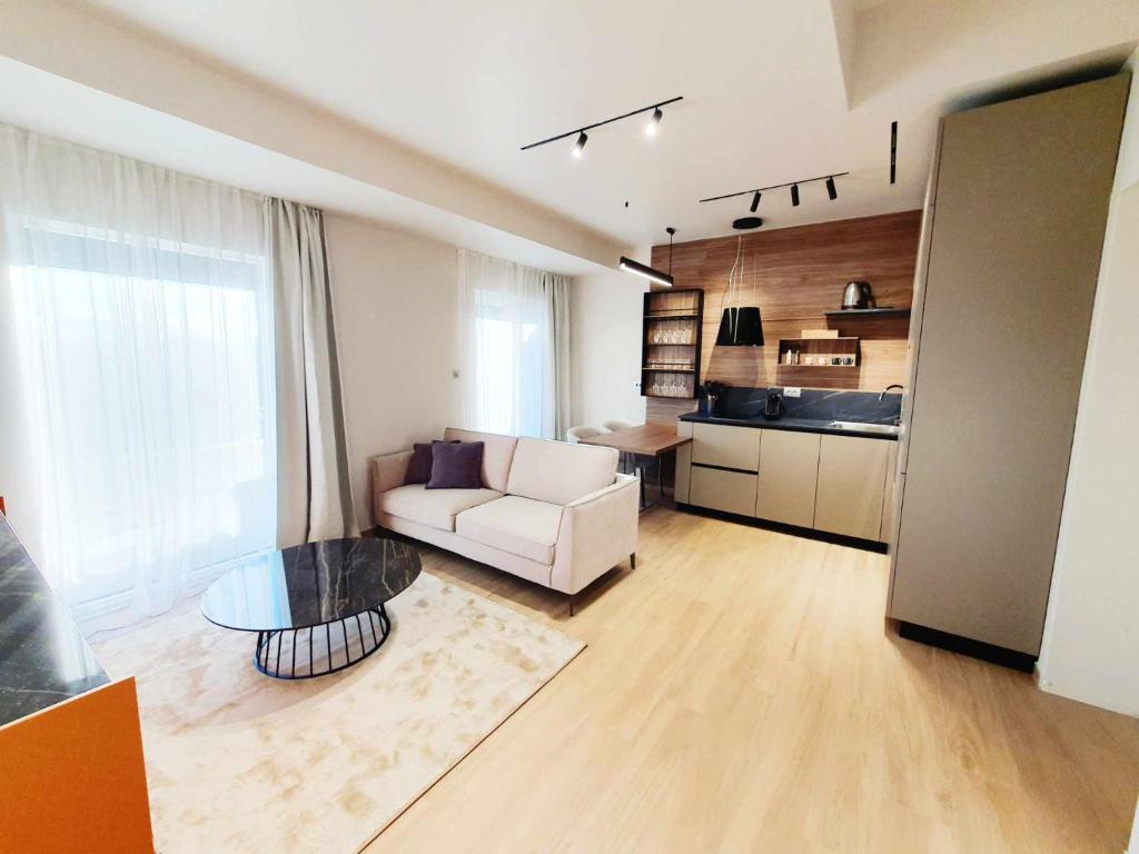 a living room with a white couch and a kitchen at NEW Ana Design City Center Apartments in Pula