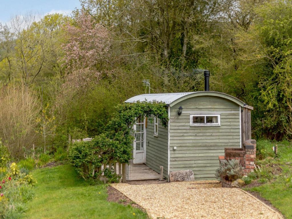 a small green shed in a garden at 1 Bed in Ironbridge 82561 in Leighton