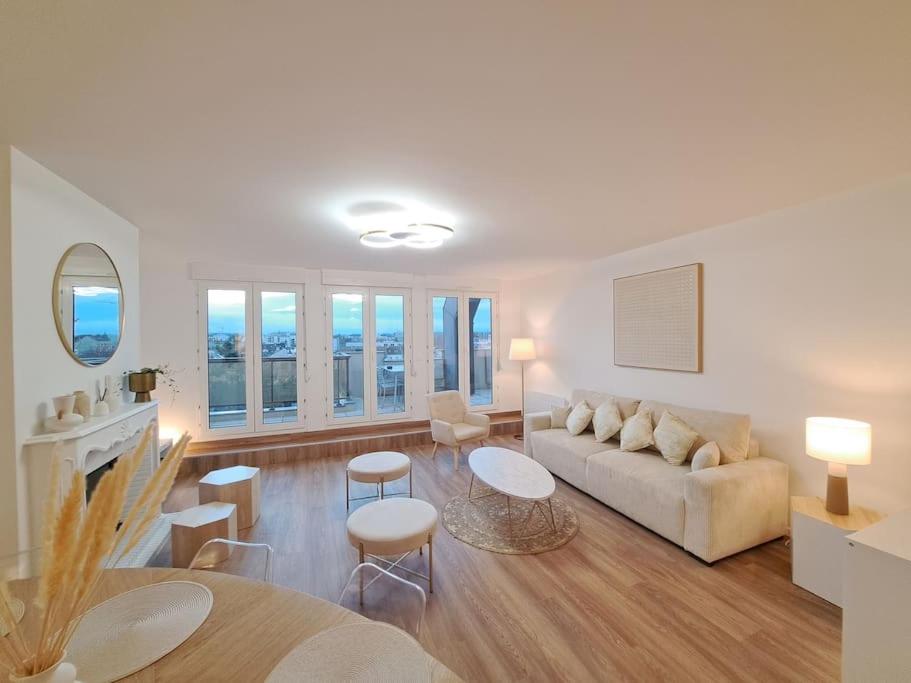 a living room with a couch and a table at Appartement "Le Biarritz" - vue Cathédrale et Parking gratuit in Reims