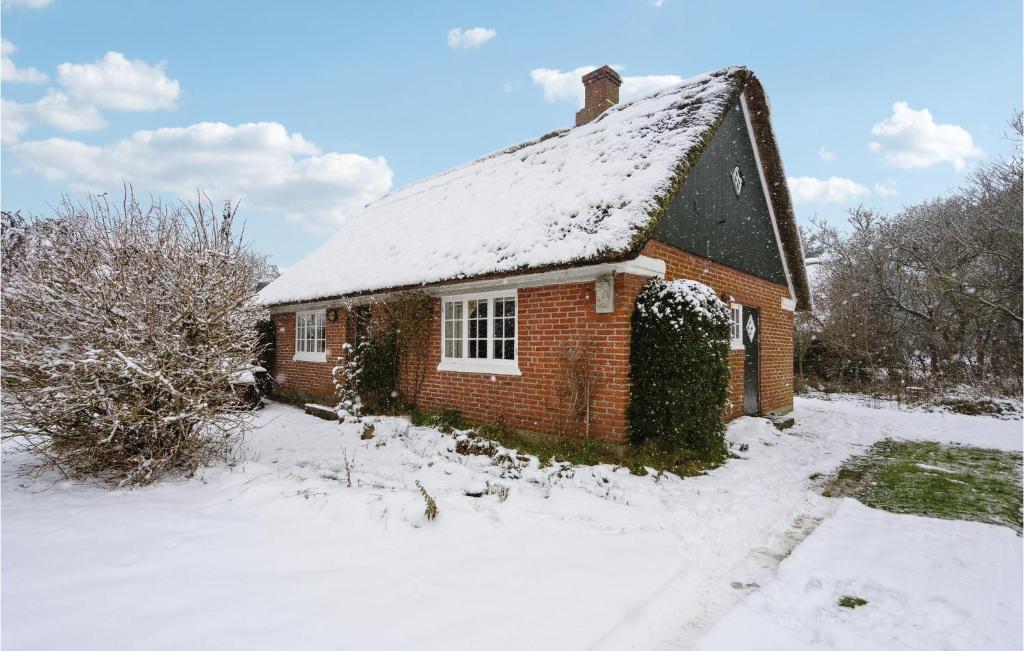 uma velha casa de tijolos com neve no telhado em Cozy Home In Fan With Kitchen em Fanø