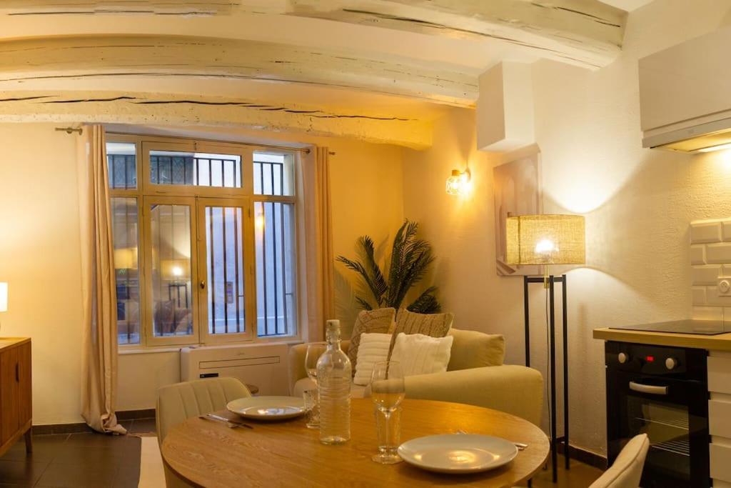 ein Wohnzimmer mit einem Tisch und einem Sofa in der Unterkunft Appartement avec cour privée + clim séjour + wifi in Avignon
