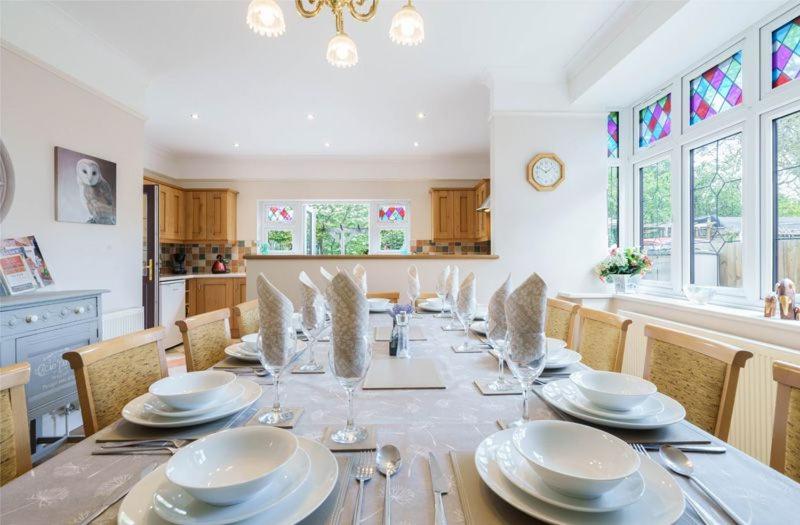 une salle à manger pourvue d'une table avec des assiettes et de l'argenterie dans l'établissement Grove Lodge, à Gosport