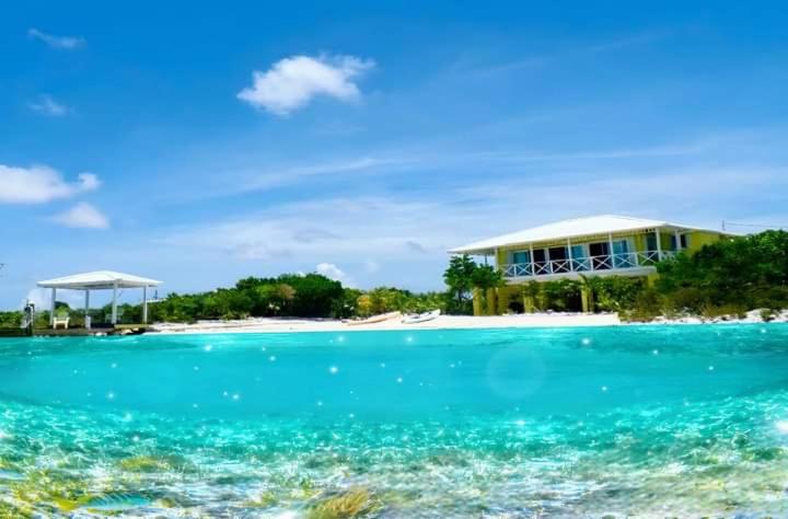 dom na tropikalnej wyspie w wodzie w obiekcie Sea Smile w mieście Staniel Cay