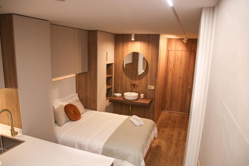 Dormitorio pequeño con cama y espejo en Suite JC1 CHIC, en Murcia