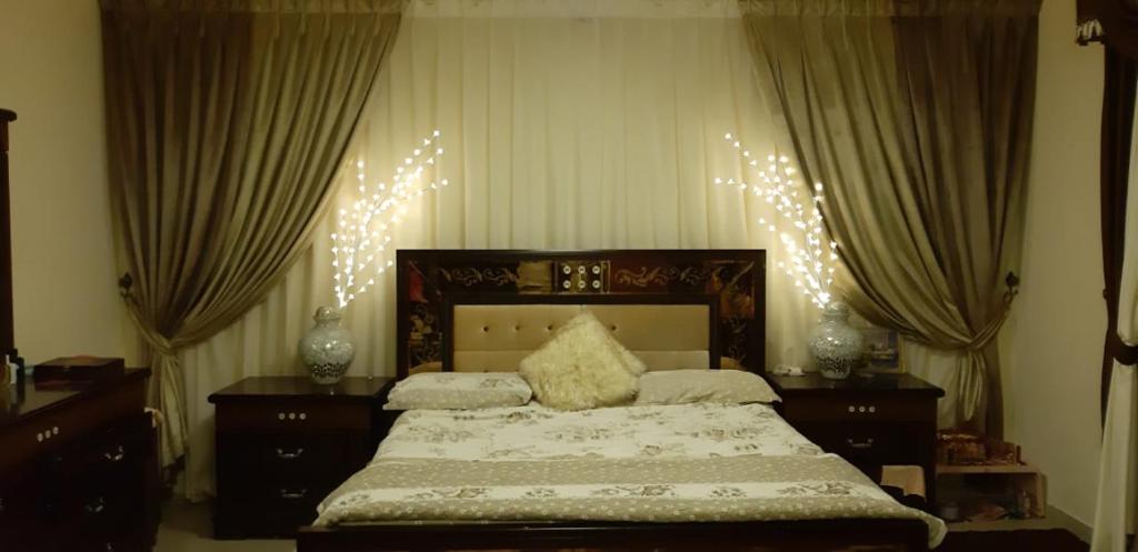 - une chambre dotée d'un grand lit avec des lumières de Noël dans l'établissement Horizon Home, à Ajman