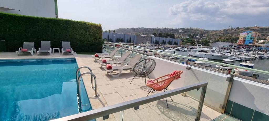 阿爾布費拉的住宿－Albufeira Marina Villa 27，阳台设有游泳池、椅子和码头