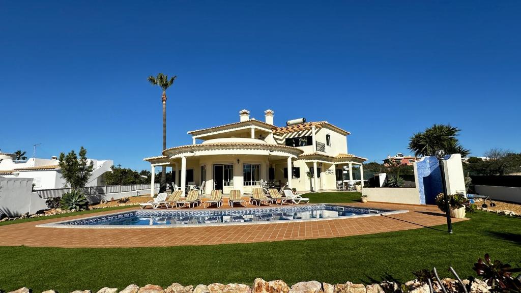 een groot huis met een zwembad in de tuin bij Santo Antonio by Check-in Portugal in Albufeira
