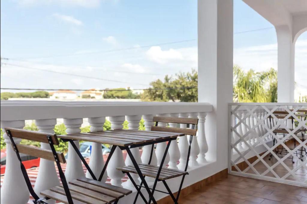 a balcony with a wooden bench and a view of the ocean at BLife Aerya private rooms in Faro