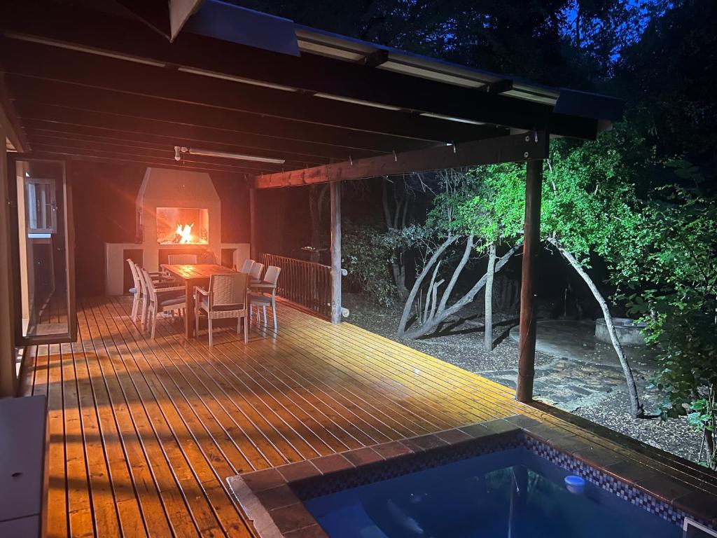 a wooden deck with a table and a fireplace at Gemsbok Place in Marloth Park