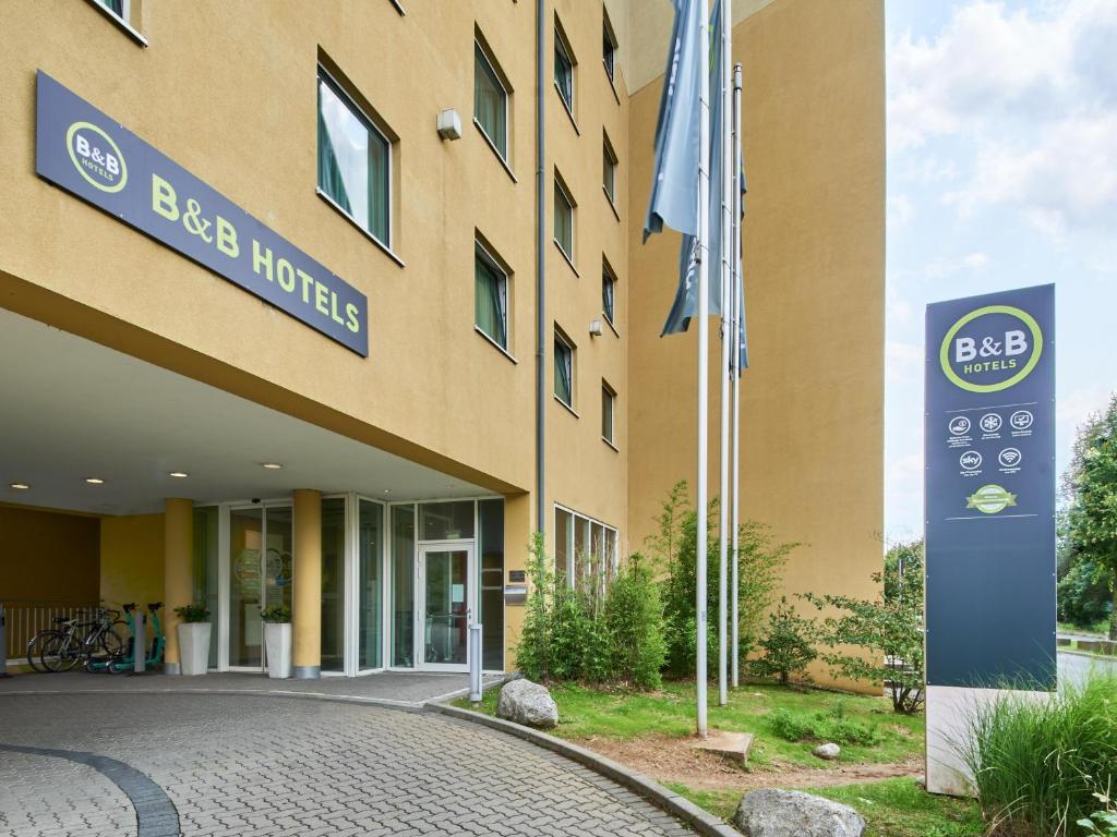 ein Gebäude mit einem Schild davor in der Unterkunft B&B Hotel Frankfurt-Messe in Frankfurt am Main