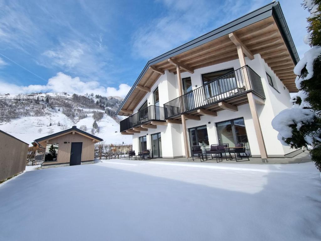 une maison avec de la neige devant elle dans l'établissement Alpen Aparts Alteck, à Rauris