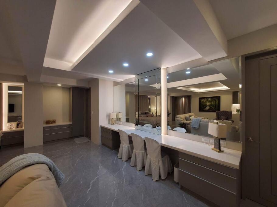 a bathroom with a long counter with a mirror at Luxury Suite in BF Homes in Manila