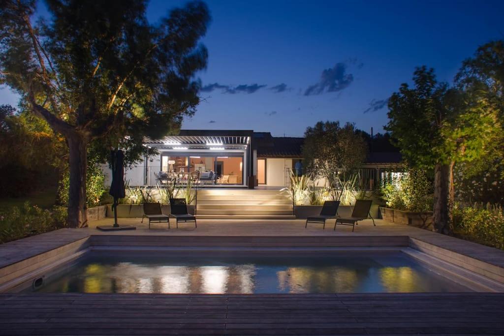 a house with a swimming pool in front of a house at Villa des jacinthes in Tarascon