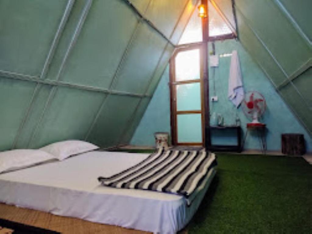 a room with a bed in a tent with a window at Nature's Hub Homestay Pasighat in Pāsighāt