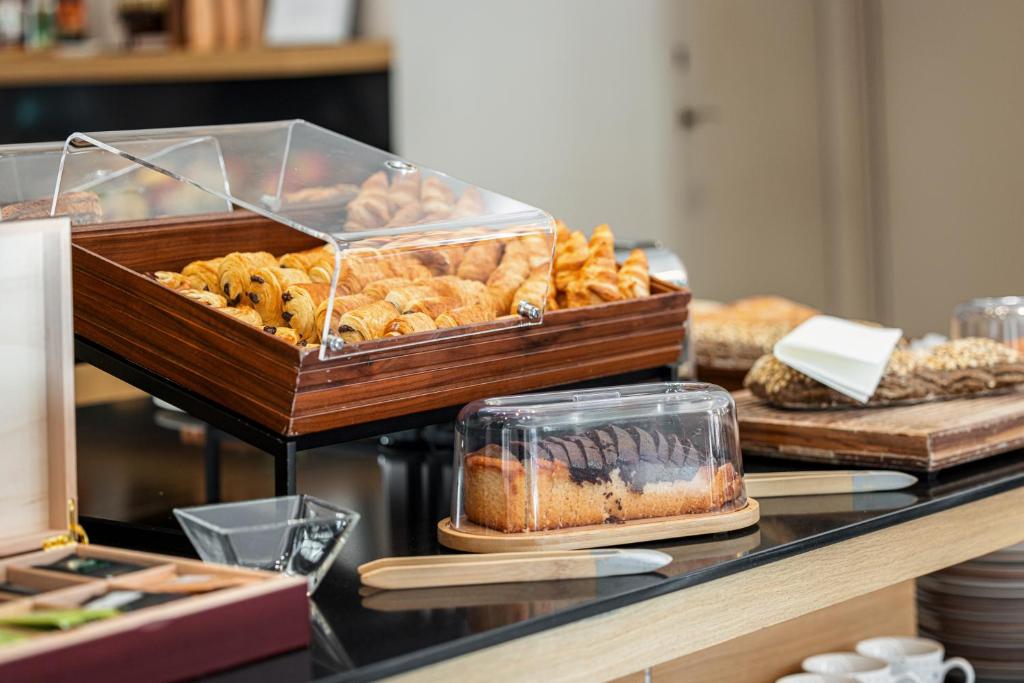 a buffet with bread and pastries on a table at Hôtel Apollinaire Nice in Nice