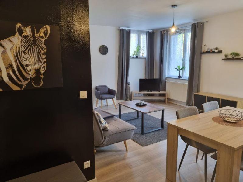 ein Wohnzimmer mit einem Zebrabild an der Wand in der Unterkunft Appart'hotel SOLESMES in Solesmes