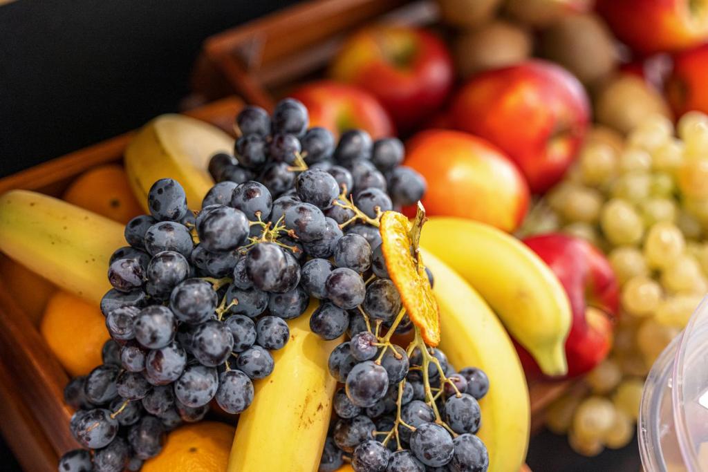 a basket of fruit with bananas and apples at Hôtel Apollinaire Nice in Nice