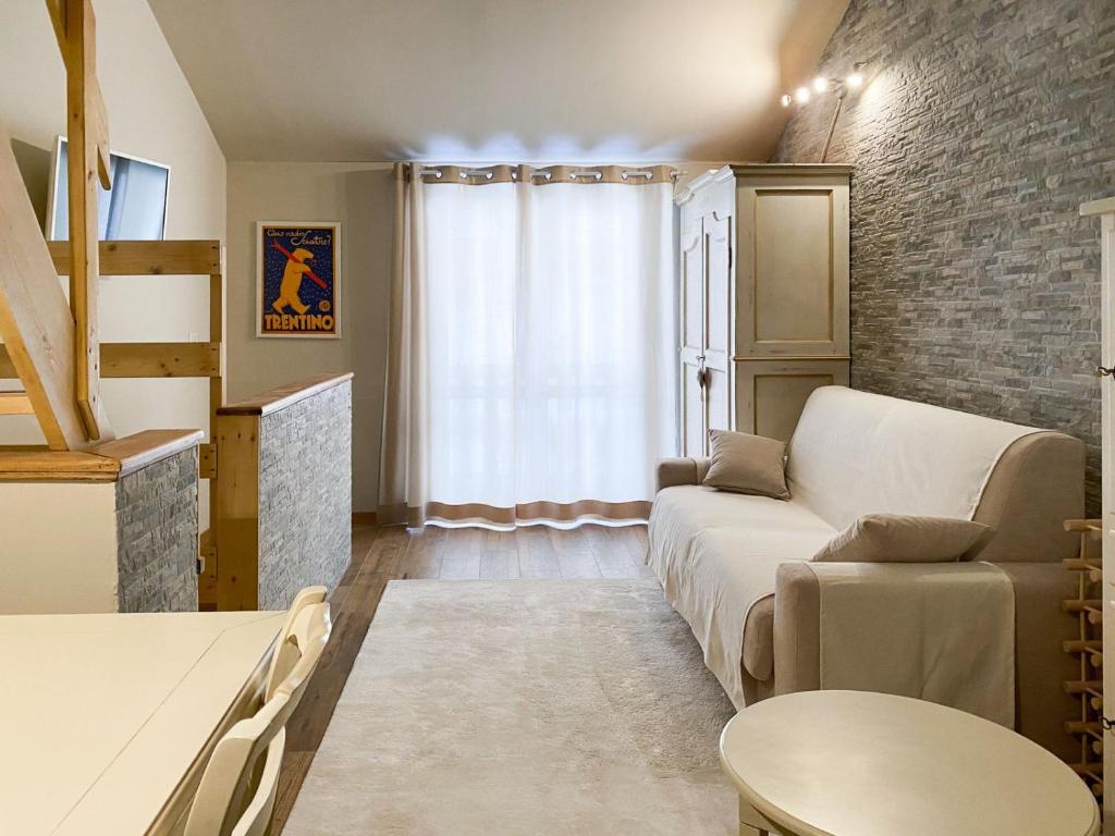 uma sala de estar com um sofá e uma mesa em Fiocco di Neve Home em Passo del Tonale
