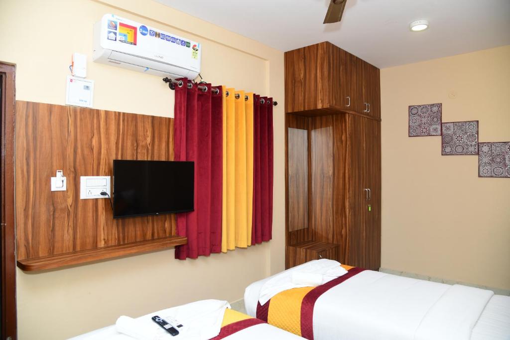 een slaapkamer met een bed en een tv aan de muur bij 1 RK AC Room with Open Terrace Manyata Tech Park in Bangalore
