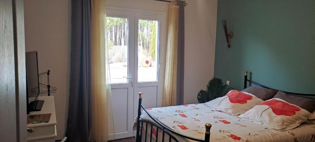 a bedroom with a bed in front of a window at Pascal et Domi CHAMBRES "l'oasis des pins" in Chateau-l'Hermitage