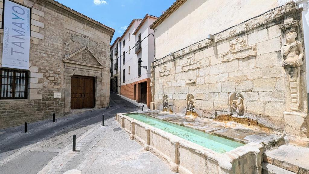 un edificio de piedra con una fuente en una calle en Los Caños - Parking opcional, en Jaén