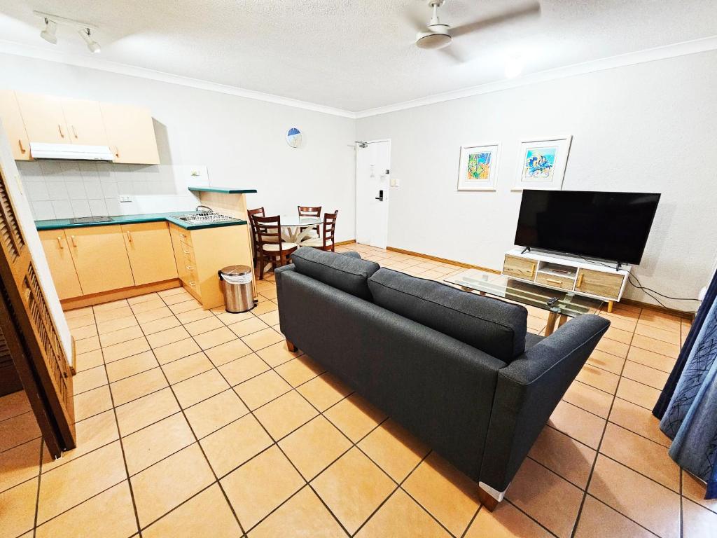 uma sala de estar com um sofá e uma televisão em Royal Palm Villas em Cairns