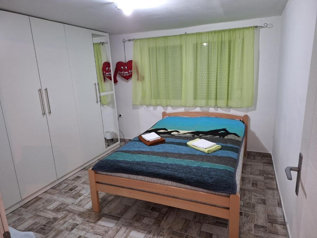 a small bedroom with a bed and a window at Apartman Jaca 