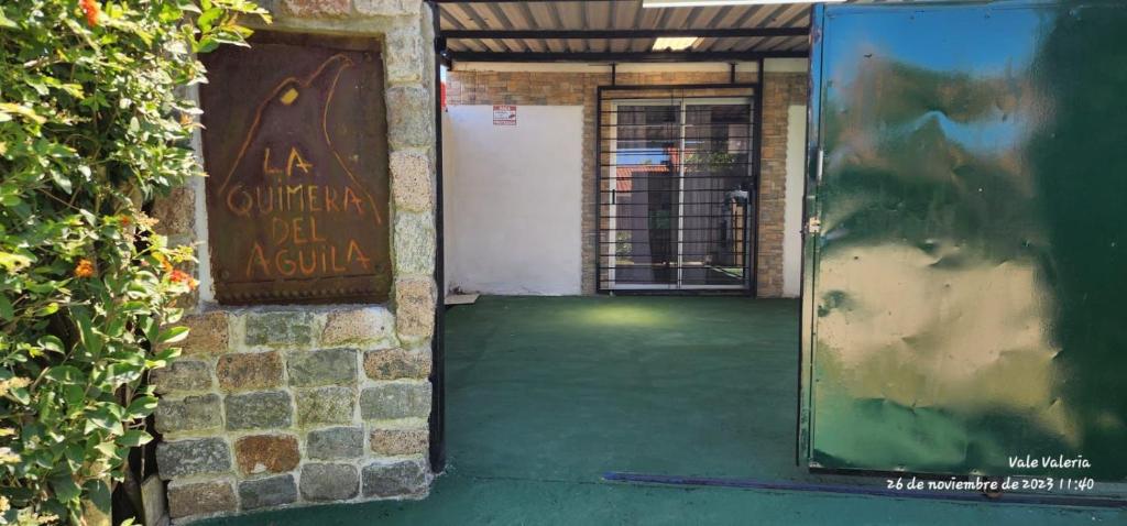 an open door with a sign on the side of a building at La Quimera del Águila in Atlántida
