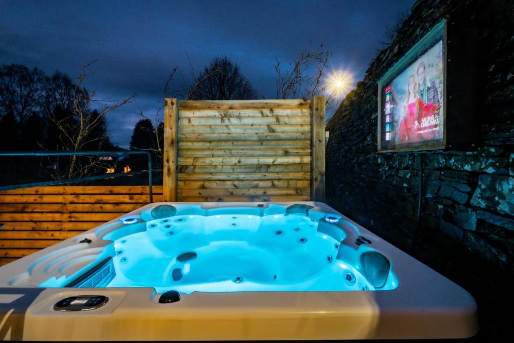 a jacuzzi tub with a tv on a wall at Beautiful Grade 2 listed building - West Wing in Bowness-on-Windermere