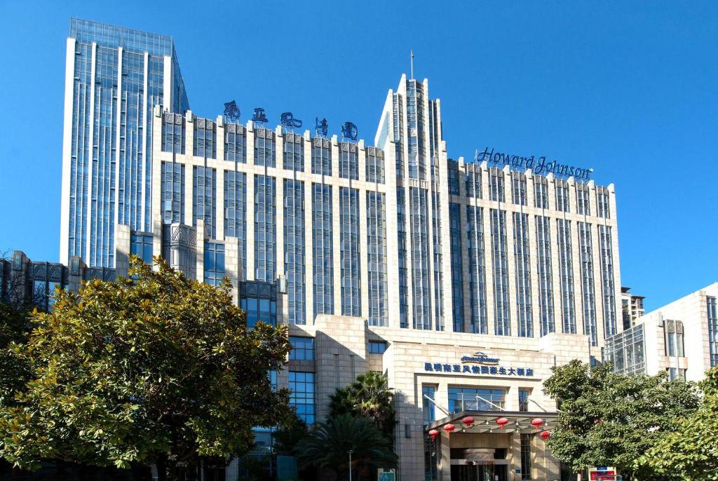 Un grand bâtiment blanc avec de nombreuses fenêtres dans l'établissement Howard Johnson Tropical Garden Plaza Kunming, à Kunming