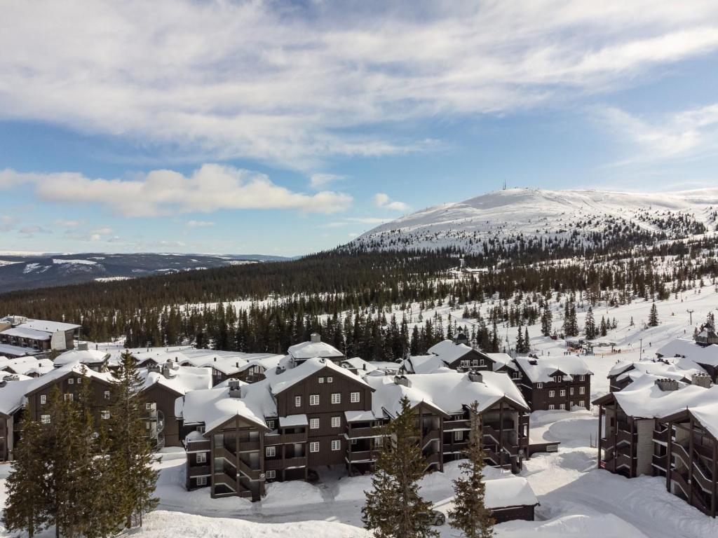 a resort in the snow with a mountain in the background at Høyfjellsgrend 962 in Trysil