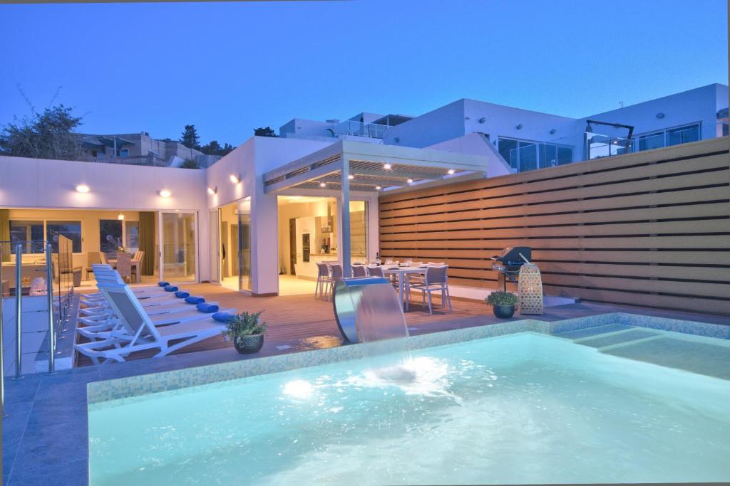 ein Pool vor einem Haus in der Unterkunft Villa Ida - Indoor Heated Pool, Sauna, Games Room and Gym in Mellieħa