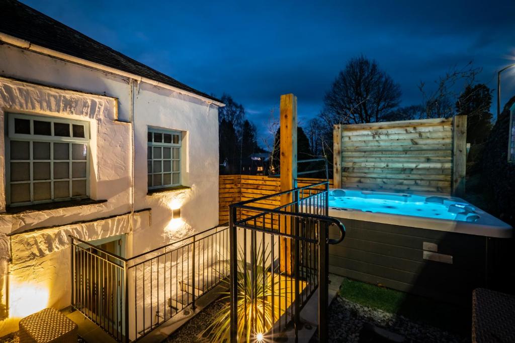 a house with a swimming pool next to a building at Grade 2 Listed 2 bedroom Pet Friendly - Parking - Hot Tub - very quiet in Bowness-on-Windermere