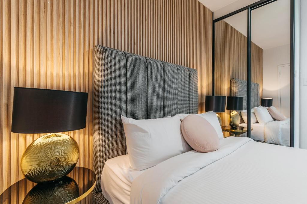 - une chambre d'hôtel avec un lit et un miroir dans l'établissement Grace at Mosman Apartments, à Sydney