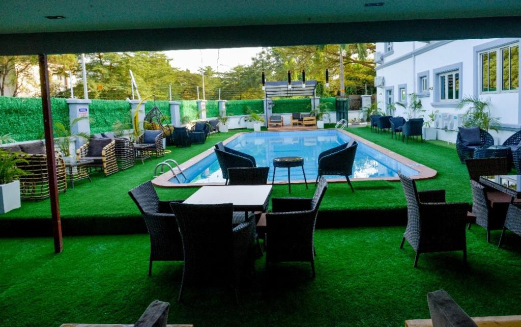 a patio with a table and chairs and a swimming pool at SS3 Jabi Hotel in Abuja