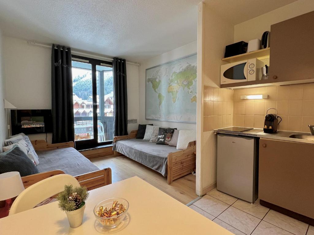 eine Küche und ein Wohnzimmer mit einem Sofa in der Unterkunft Le Balme Studio WiFi/Parking/Balcony in Chamonix-Mont-Blanc
