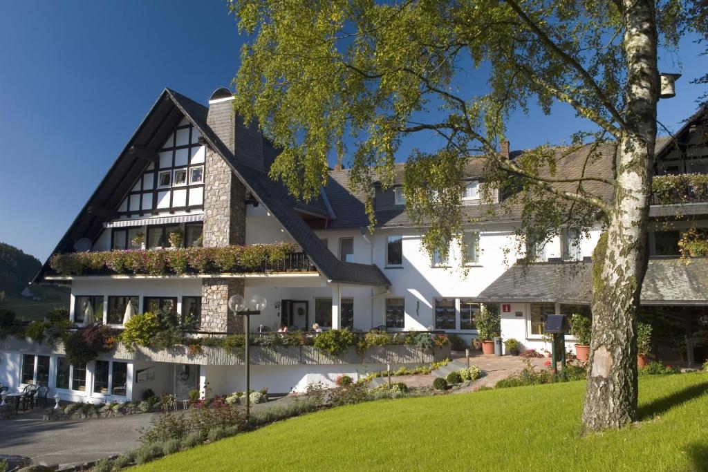 a large white building with a tree at Hotel Stockhausen GbR in Schmallenberg