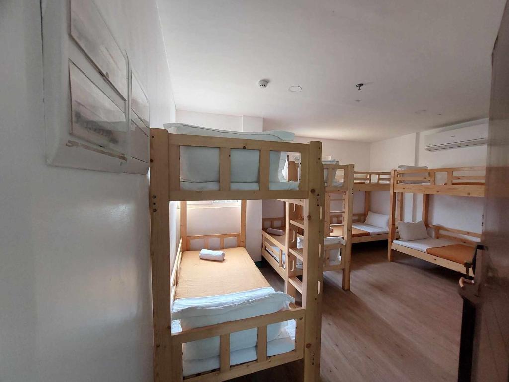 a room with three bunk beds and a refrigerator at Emerald Bay Boracay in Boracay